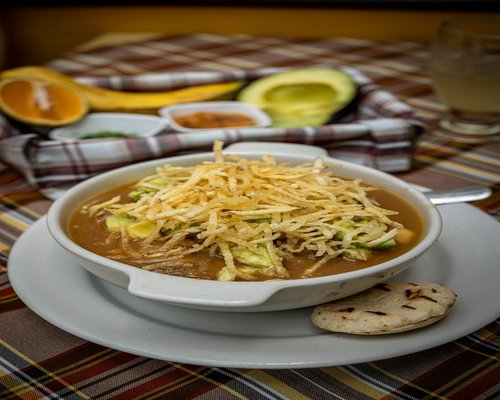A freshly made traditional Mexican soup bowl containing beans and avocado slices